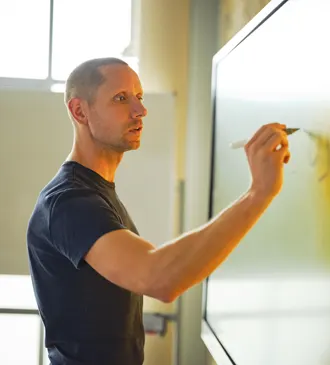 Roy Mönster schreibt an ein Whiteboard